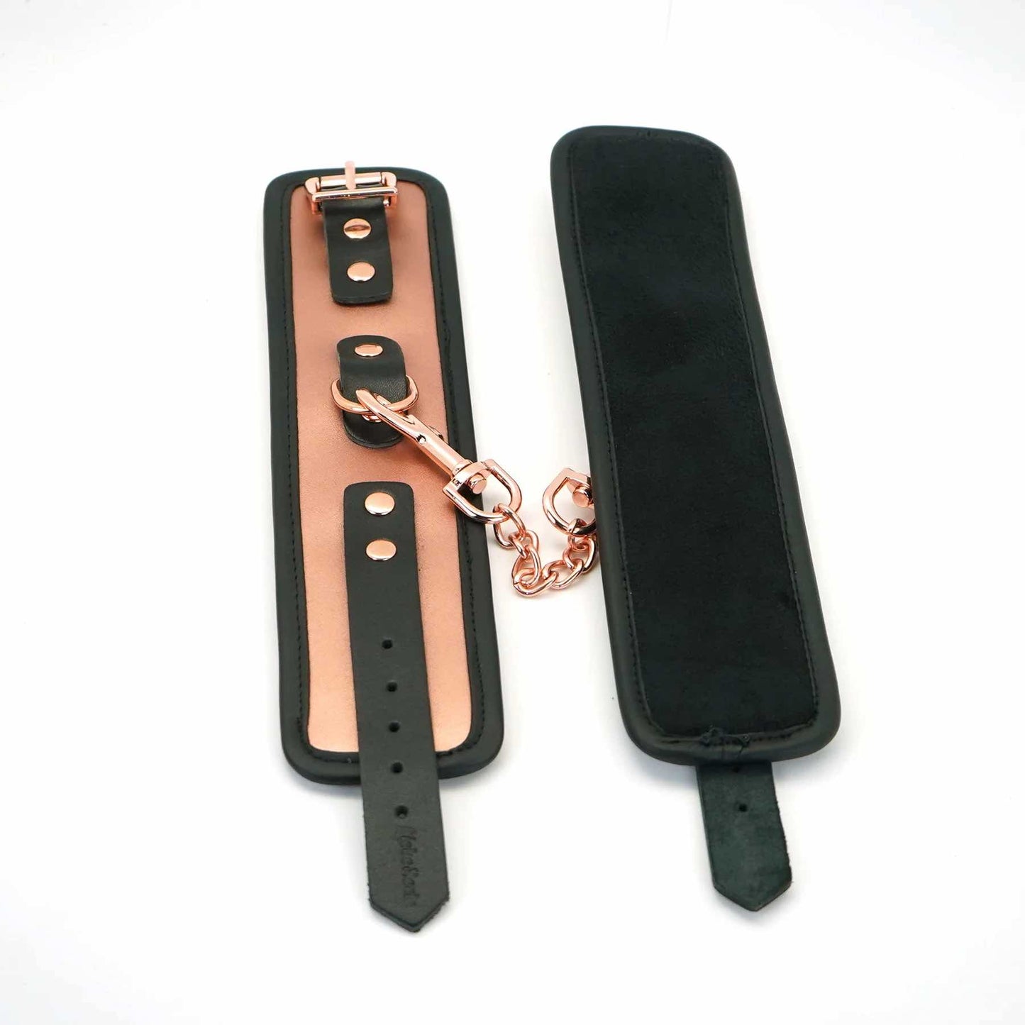 The Rose Gold Memory Leather Cuffs with Faux Fur LIning open and lying flat next to each other with one cuff flipped to show its inside.