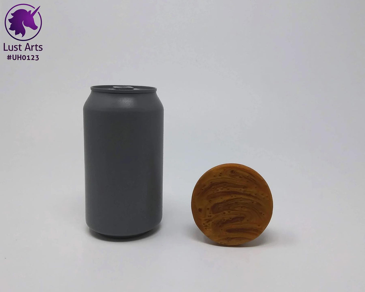 The Firm Teaser Sunlight Unicorn Horn Dildo laying down showing its base next to a cola can for size reference.