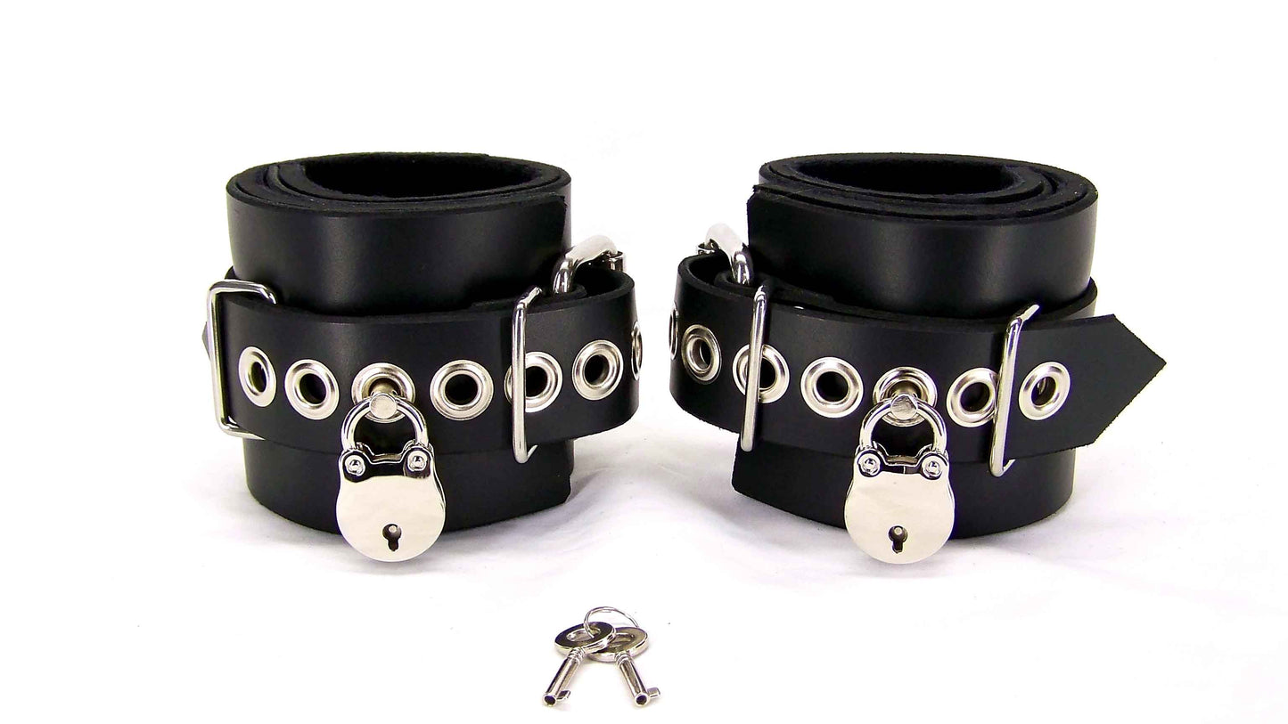 Black neoprene lined bondage cuffs with tentacle eyelets and lock closure against white background.