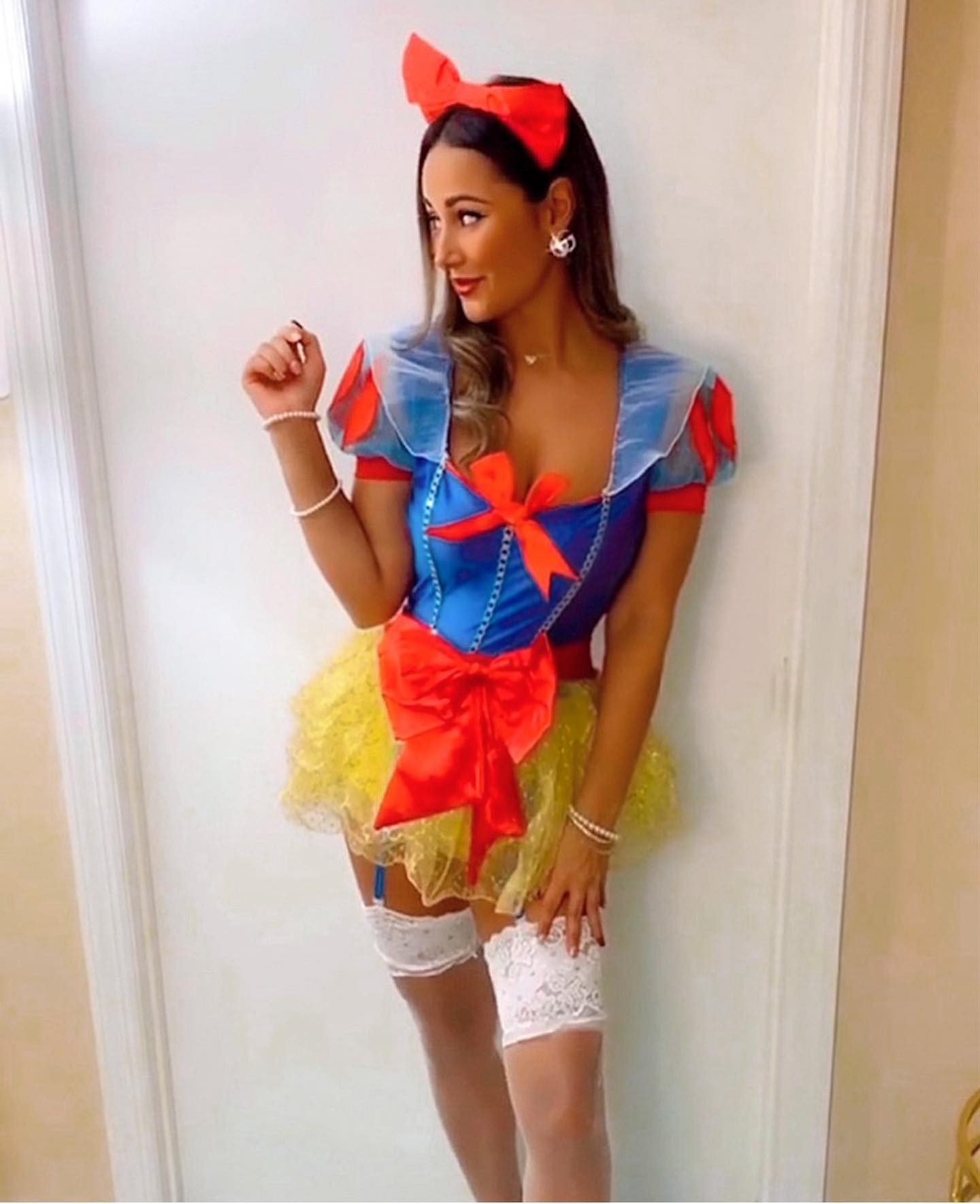 Model wearing a Sexy Snow White cosplay outfit featuring the white Sheer Stay Up Lace Top Thigh Highs.