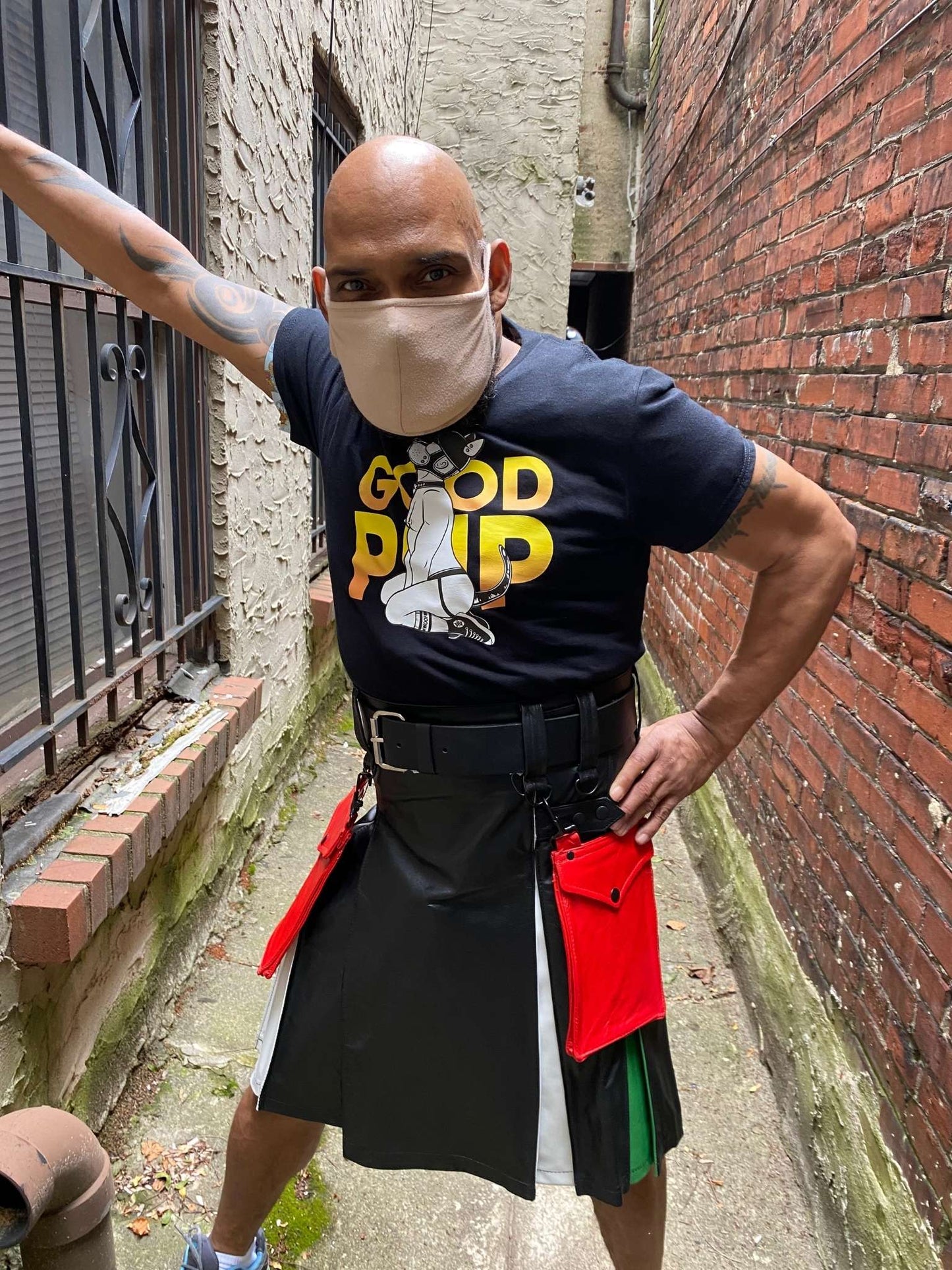 Model wearing leather boy pride flag heritage kilt, with black good pup t-shirt, and two detachable red leather kilt pockets.