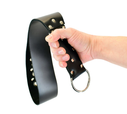 A model's hand holding the black big leather slapper strap with tentacle detailing featuring the flat side.