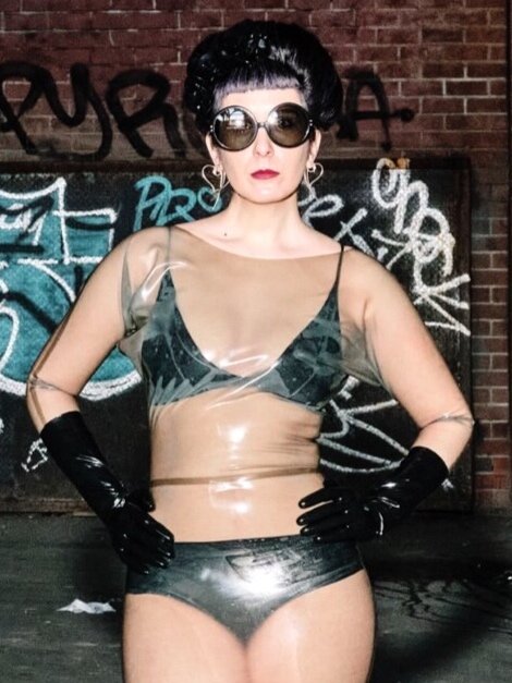 Latex black etched floral Bralette Under a Clear Latex Dress, front view.