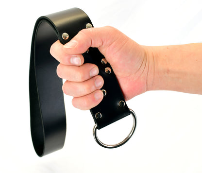 A model's hand holding the plain black big leather slapper strap.