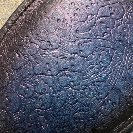 A close up of the blue and black two toned Round Paddle with skeleton pattern.