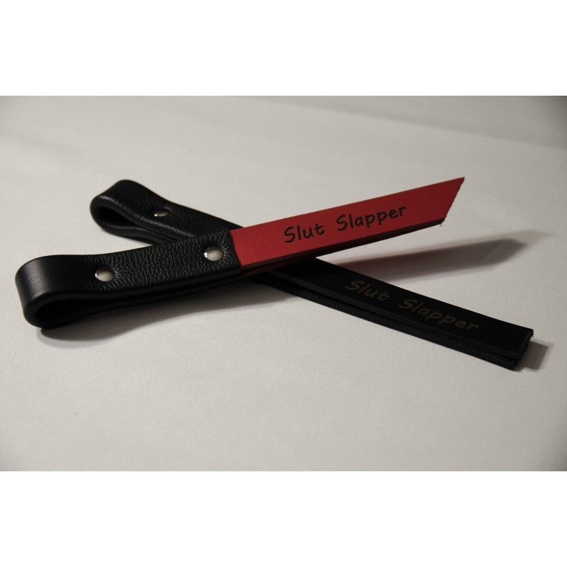 1 inch red and 1 inch black leather slapper with the words slut slapper printed on them.