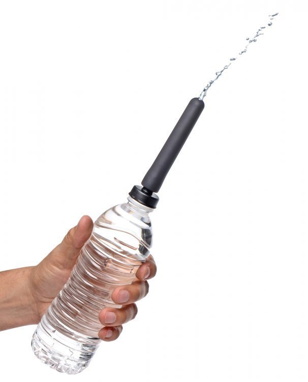 The nozzle and adapter attached to a water bottle being squeezed so that water shoots out.