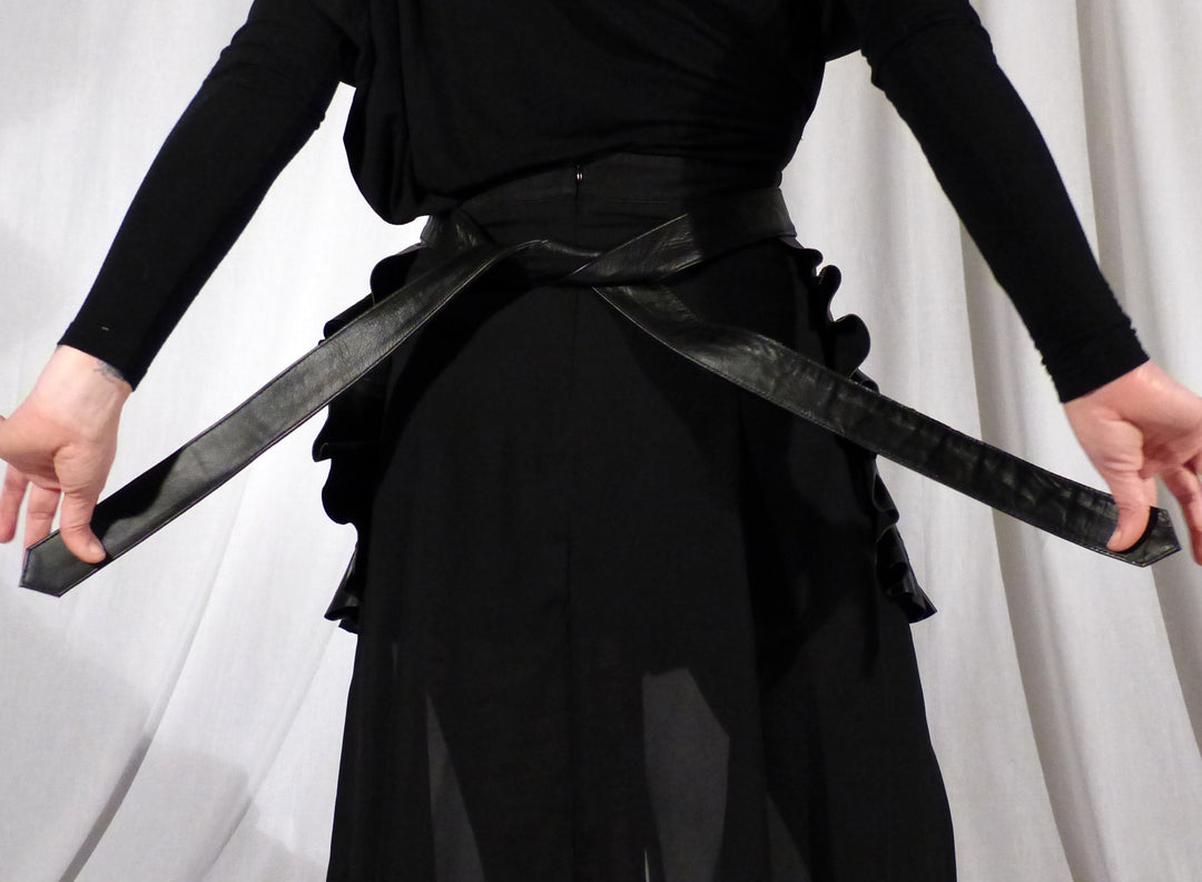 The back tie closure of the Leather Ruffle Half Apron.
