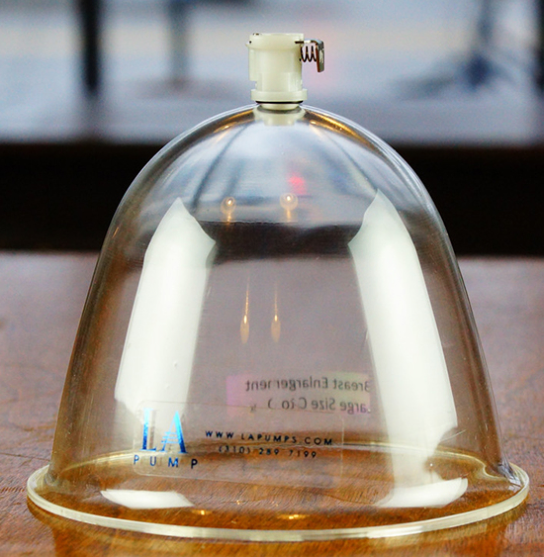 A single Breast Suction Cup sitting on a wooden table.