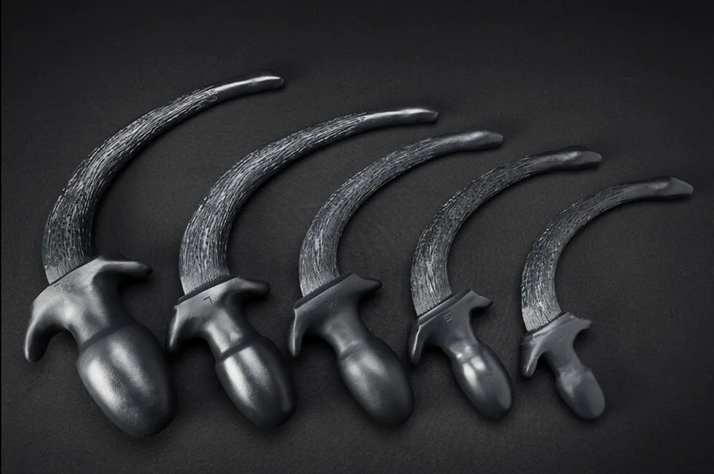 A display of 5 different sized Silicone Puppy Tail Plugs.