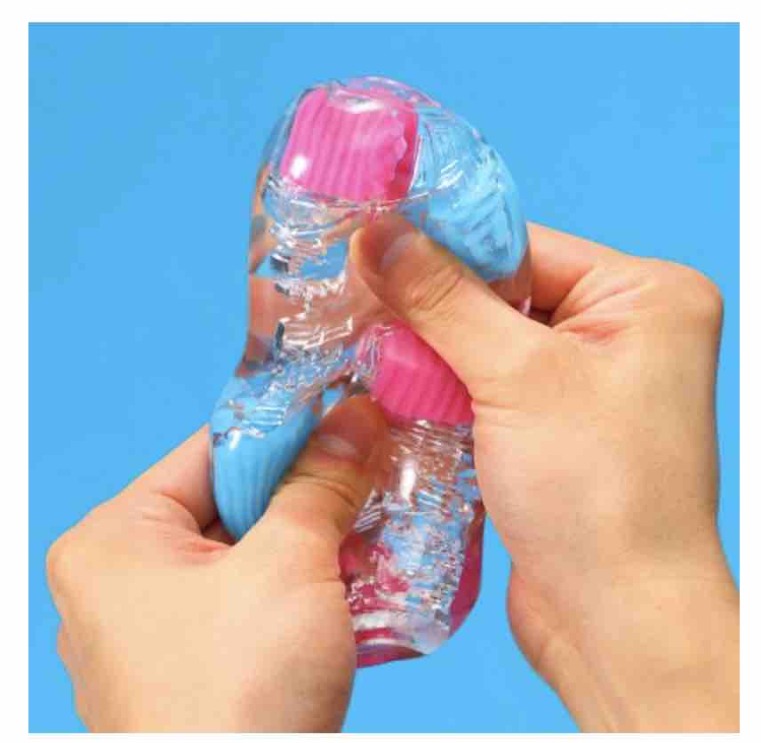 Two hands squeezing the stroker to show how soft and pliable it is.