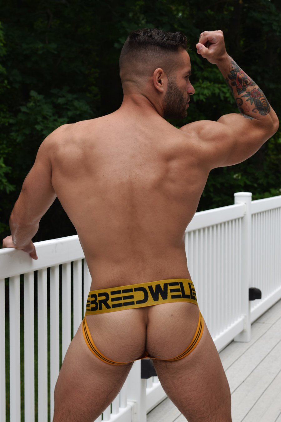 A model displaying the back of the yellow CumDump Jockstrap.