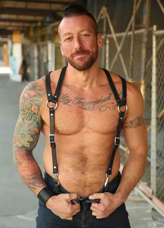 Shirtless model wearing jeans and showing the front of the Leather Double Strap Suspender Harness.