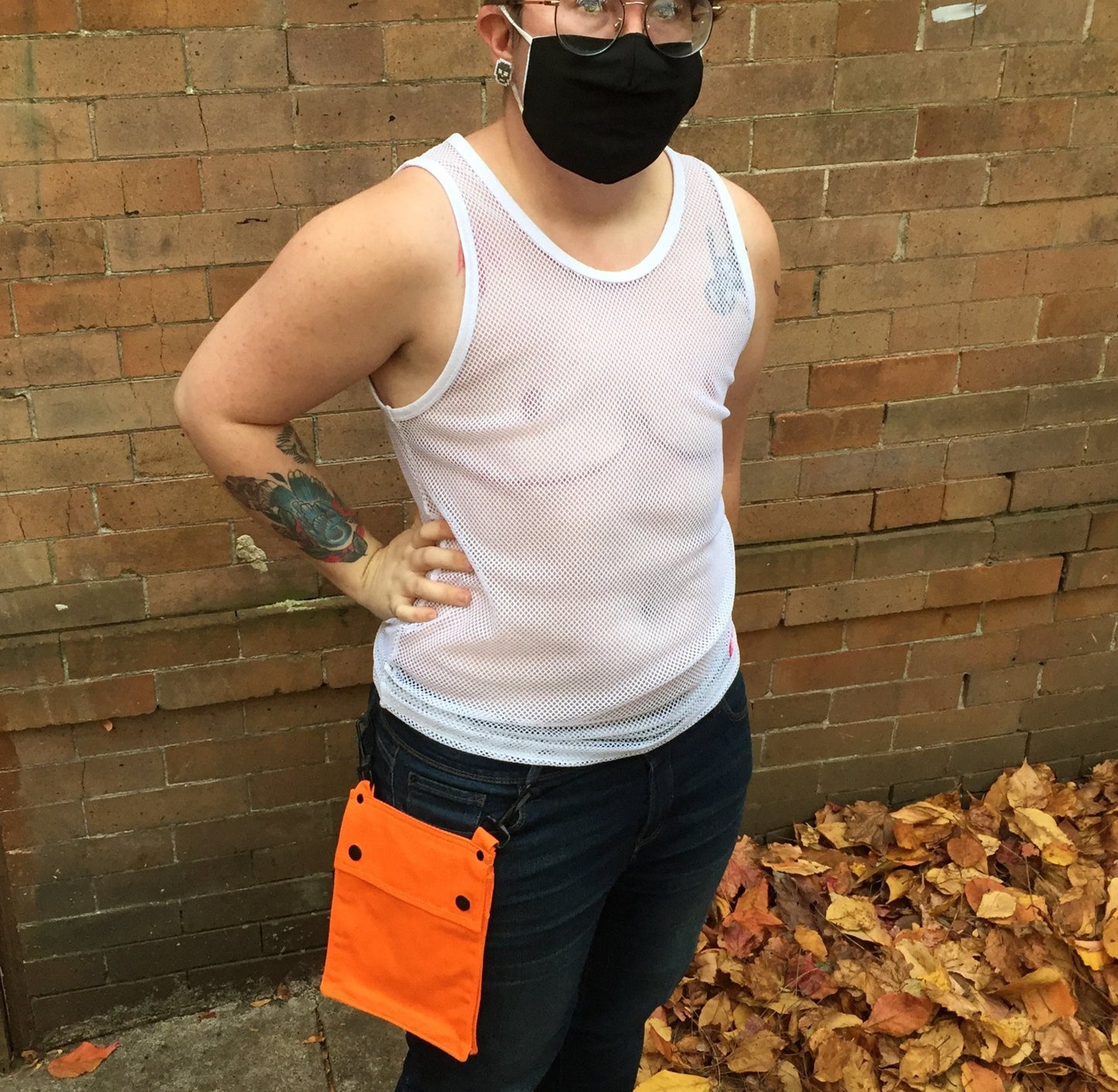 A model wearing the orange Detachable Pocket for Heritage Kilt hooked to their jeans belt loops.