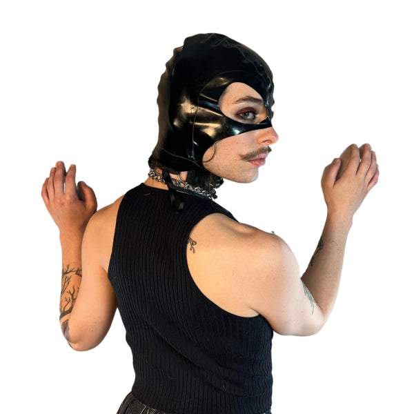 A model wearing black open mouth and eye basic latex hood, side view.