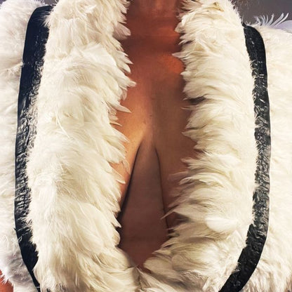 The white latex feather boa covering most of model's chest.