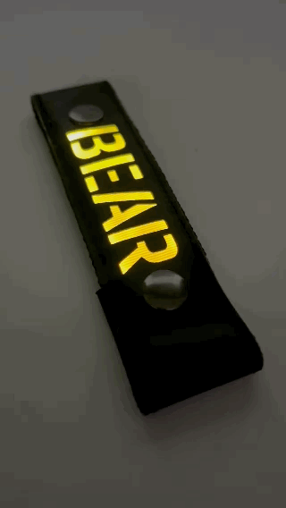 A Gif of the "BEAR" Glow Center Strap flashing in different colors.