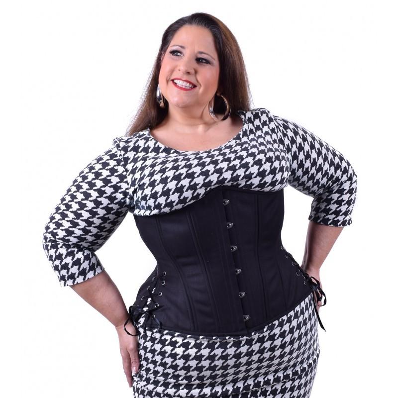 A plus size model wearing the Black Cotton Cashmere Longline Underbust Corset - Hourglass over a black and white houndstooth dress, front view.