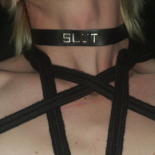 Topless model in rope harness wearing SLUT word collar. 