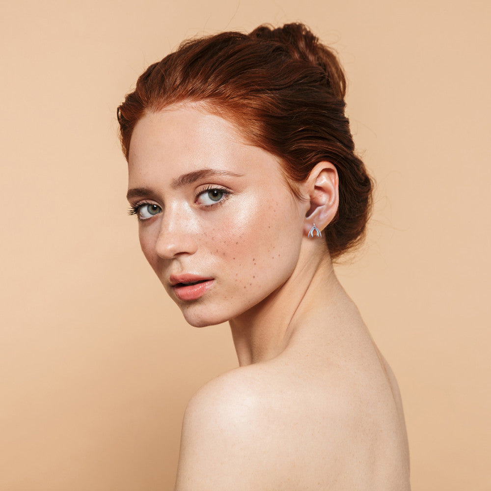 A model wearing the Clit Earrings.