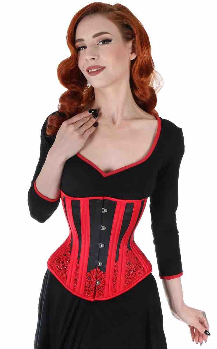 A model wearing the red and black Cabaret Sparkle Lace Satin Mid-Length Underbust Corset - Hourglass over a black dress, front view.