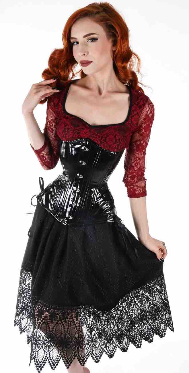 A model wears the Black Patent PVC Longline Underbust Corset - Hourglass over a red lace blouse and black skirt.