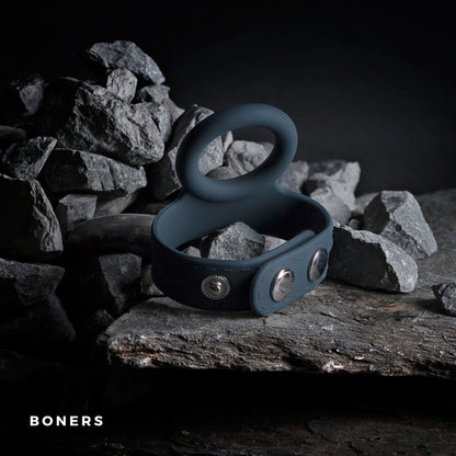 The Boners Cock & Ball Strap artfully balanced on gray rocks.