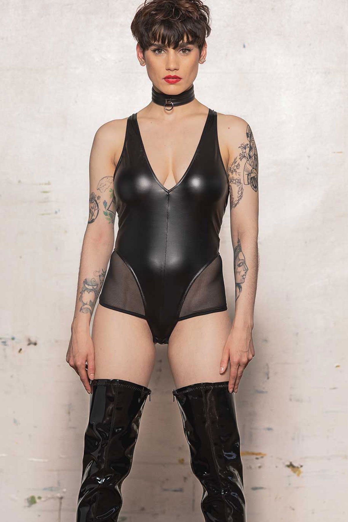 Model wearing the Avalanche PVC and Mesh Playsuit with PVC thigh high boots, front view.