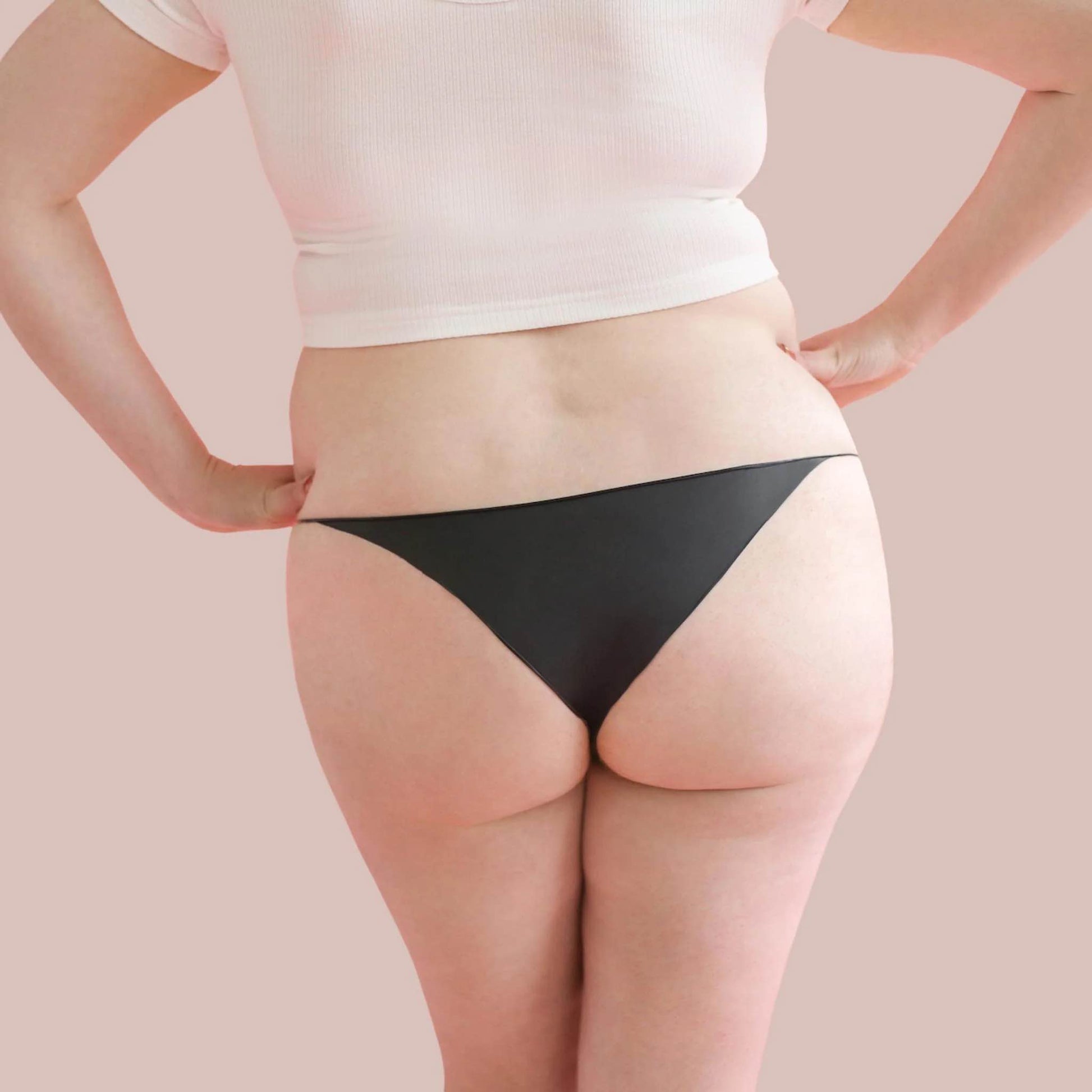 A plus size model wearing the opaque black bikini Lorals Panties For Pleasure and Comfort, rear view.