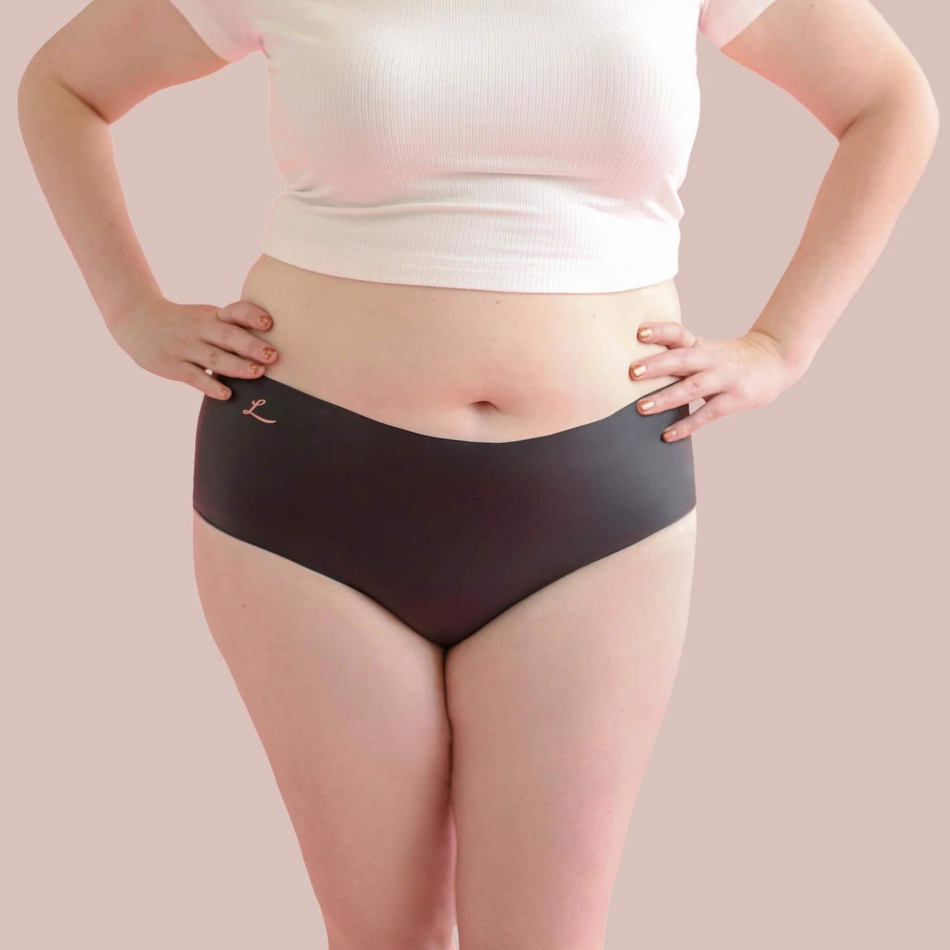 A plus sized model wearing the opaque black shortie Lorals Panties For Pleasure and Comfort, front view.