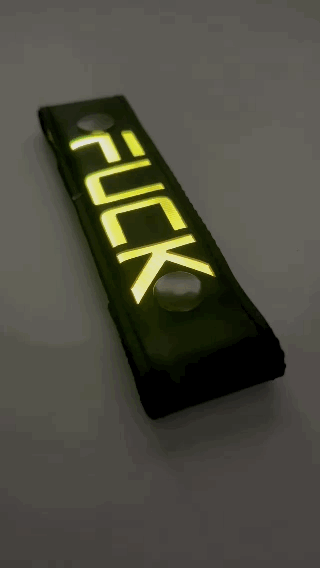 A Gif of the "FUCK" Glow Center Strap flashing in different colors.