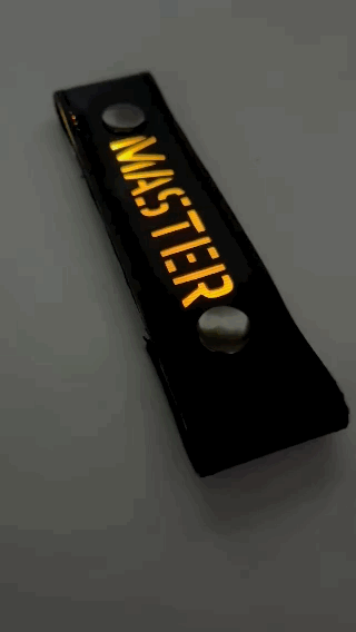 A Gif of the "MASTER" Glow Center Strap flashing in different colors.