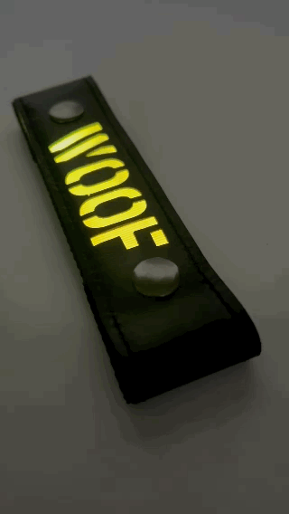 A Gif of the "WOOF" Glow Center Strap flashing in different colors.