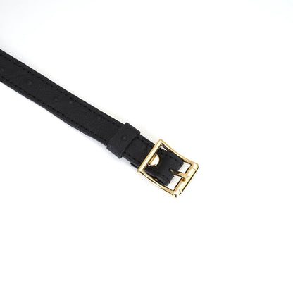 A close up of the buckle end of the Demon's Kiss Ostrich Texture Leather Large Letter Slut Collar.