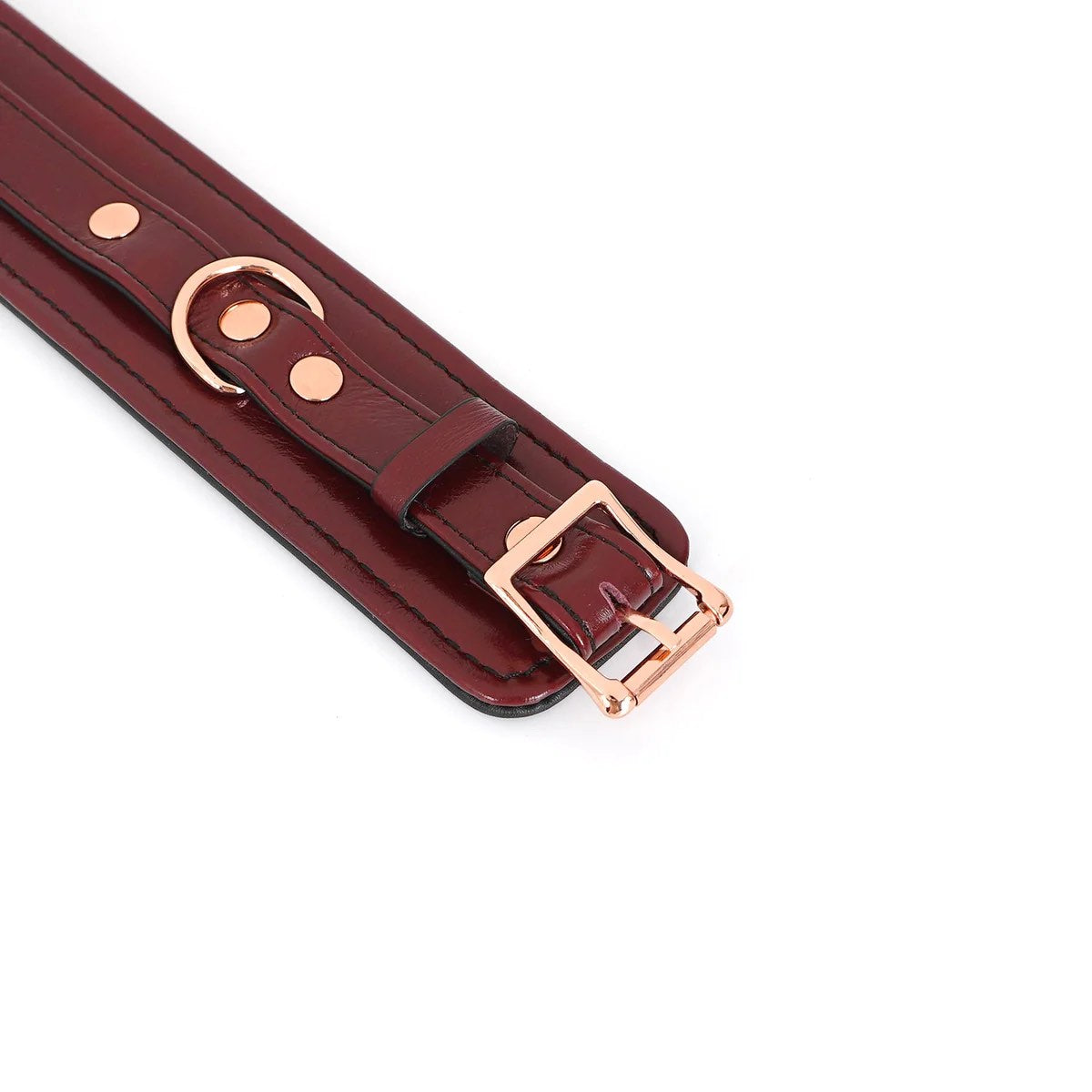 A close up of the buckle end of the Burgundy Leather Cuffs with Rose Gold Hardware.