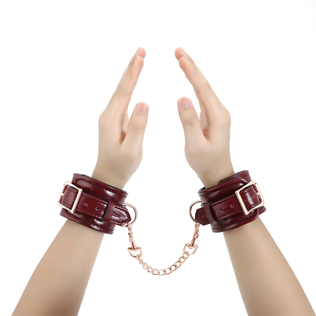 The Burgundy Leather Cuffs with Rose Gold Hardware on a model's wrists.