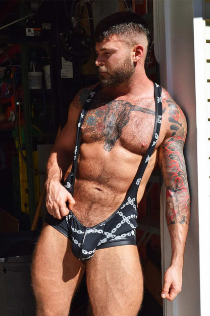 A model leaning next to a door jam wearing the Dirty Boy Chains Singlet.