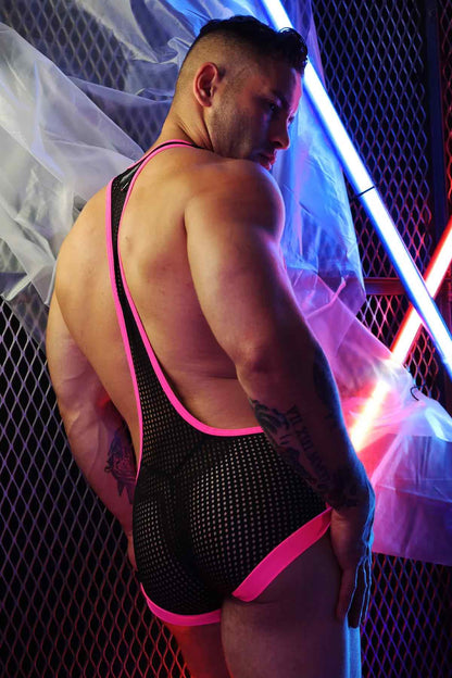 A model wearing the pink and black Dirty Boy Neon Trim Singlet against a fence lit with neon lights, rear view.