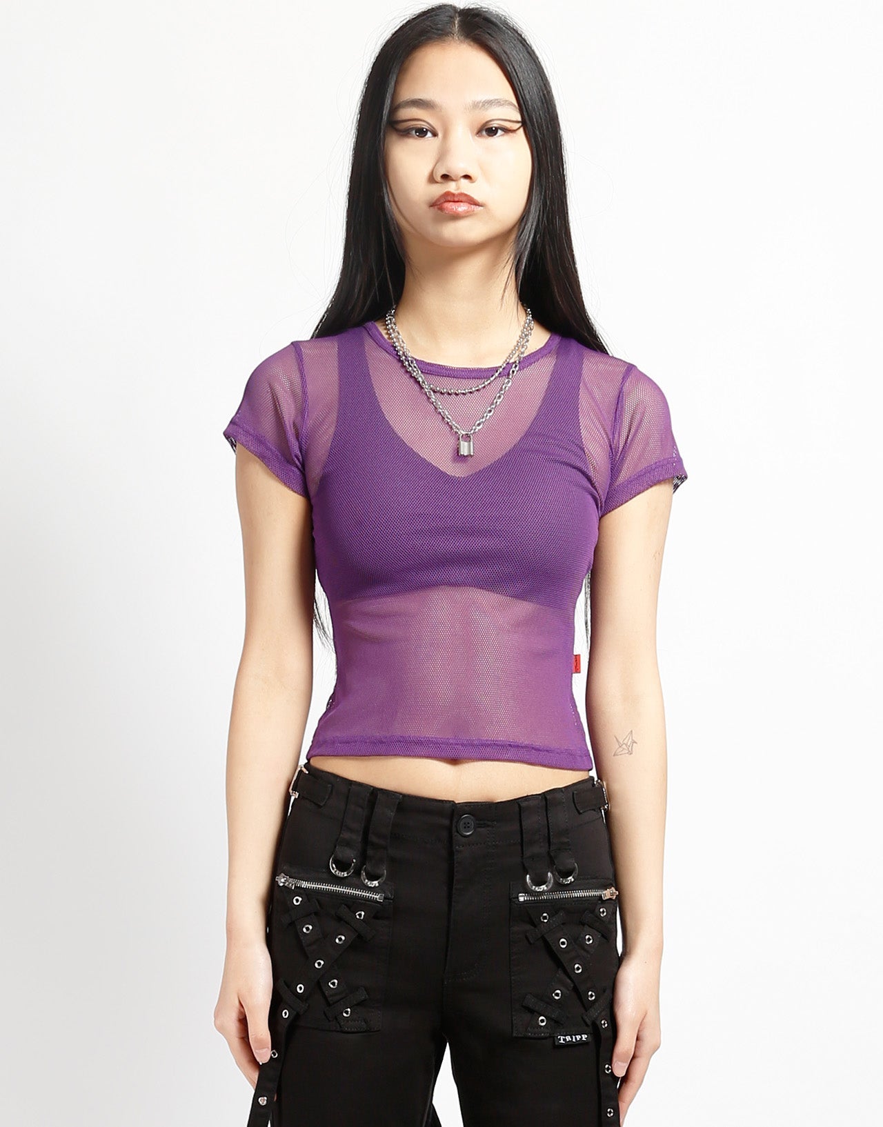 A model wearing the purple Baby Short Sleeve Fishnet Tee Shirt with black pants, front view.