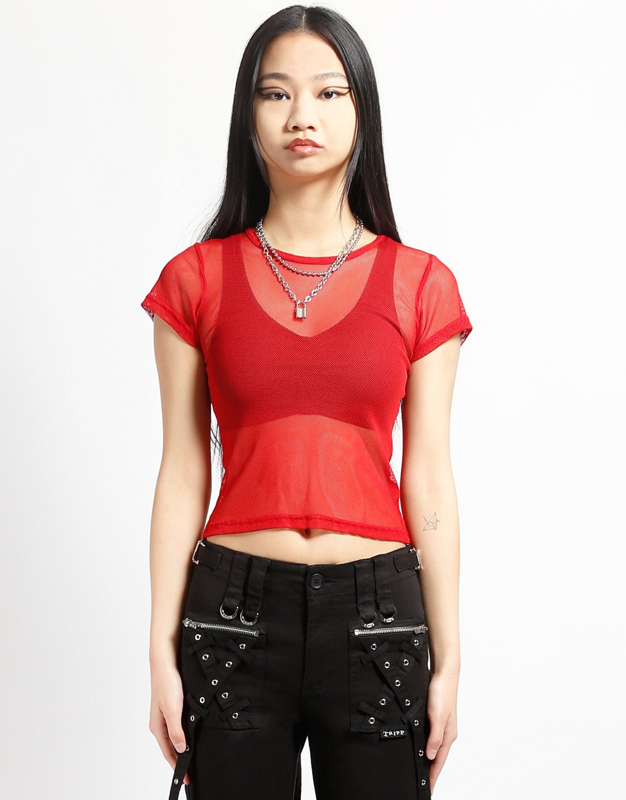 A model wearing the red Baby Short Sleeve Fishnet Tee Shirt with black pants, front view.