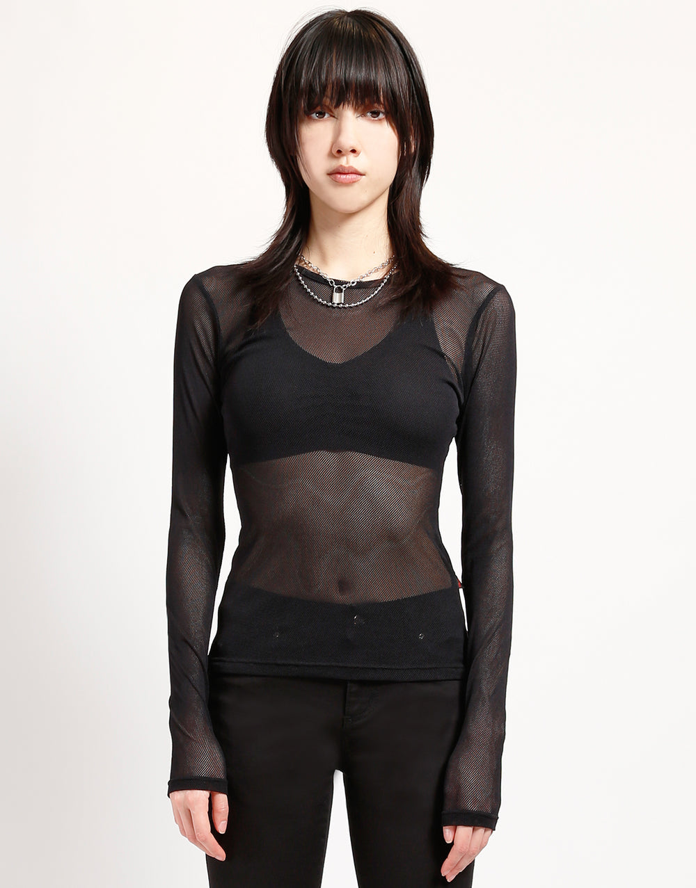 A model wearing the black Long Sleeve Baby Doll Fishnet Shirt with black bra and pants, front view.