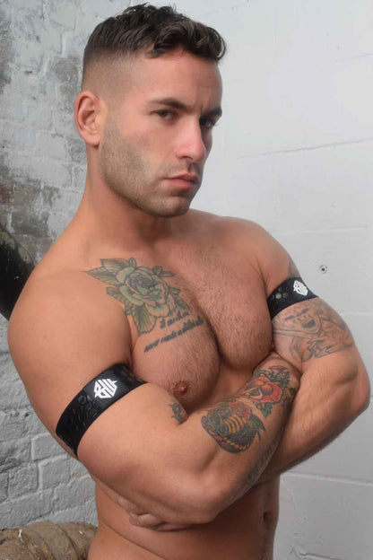 A model with arms crossed wearing the black Hex Armband on both arms.