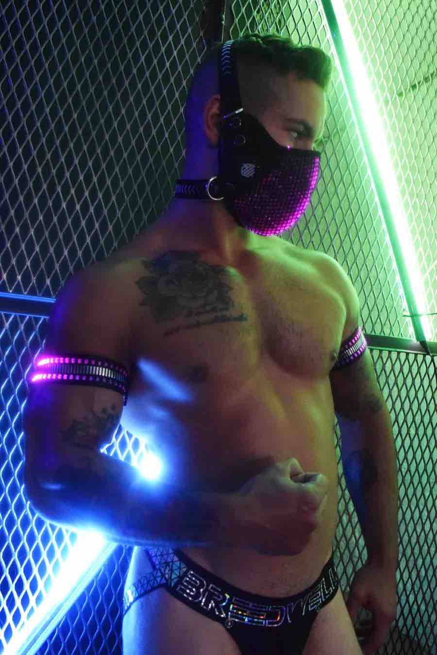 A model wearing the Mirror Light Armbands on both arms with pink lights showing.