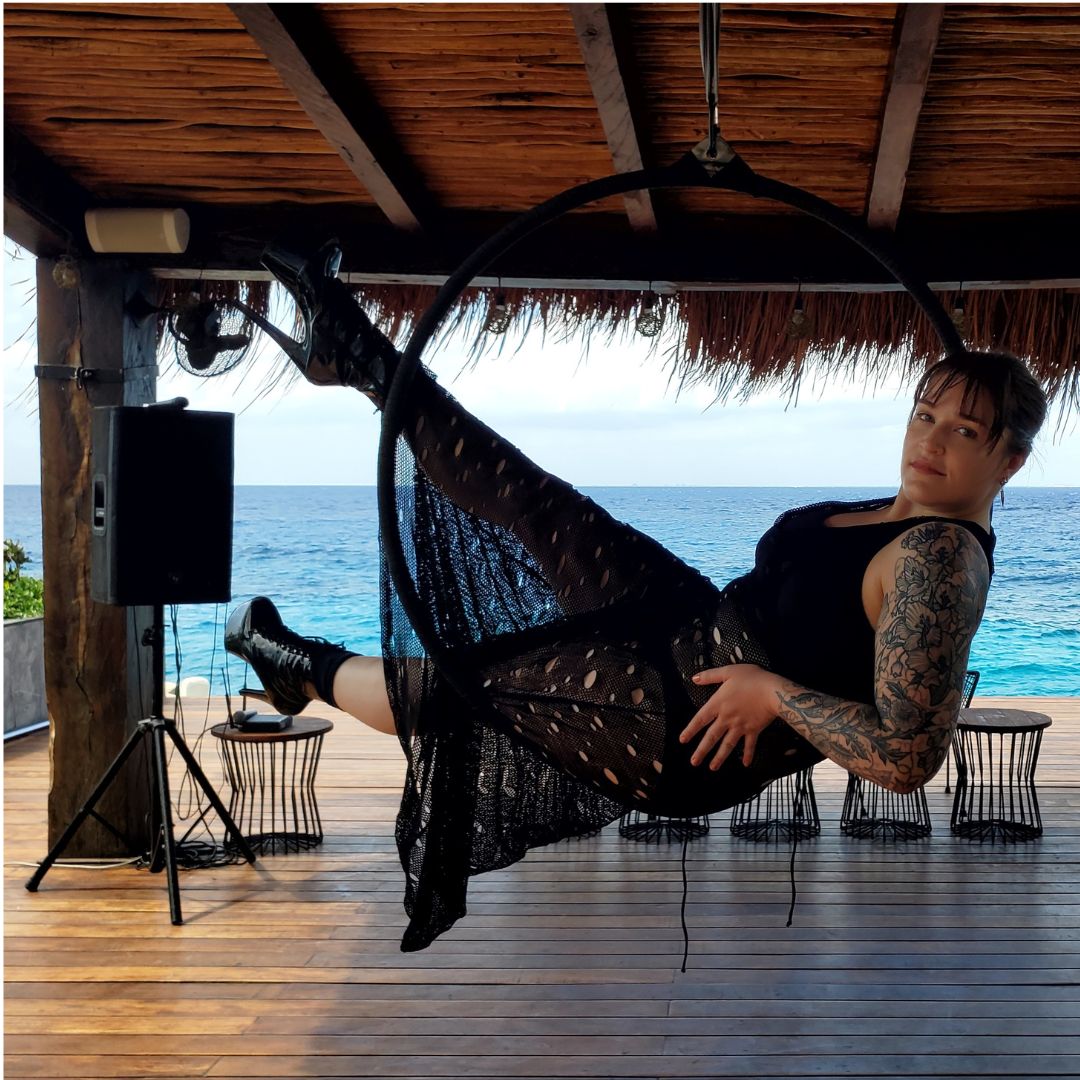 Model sitting in Arial Hoop wearing Jax Fishnet Maxi Dress