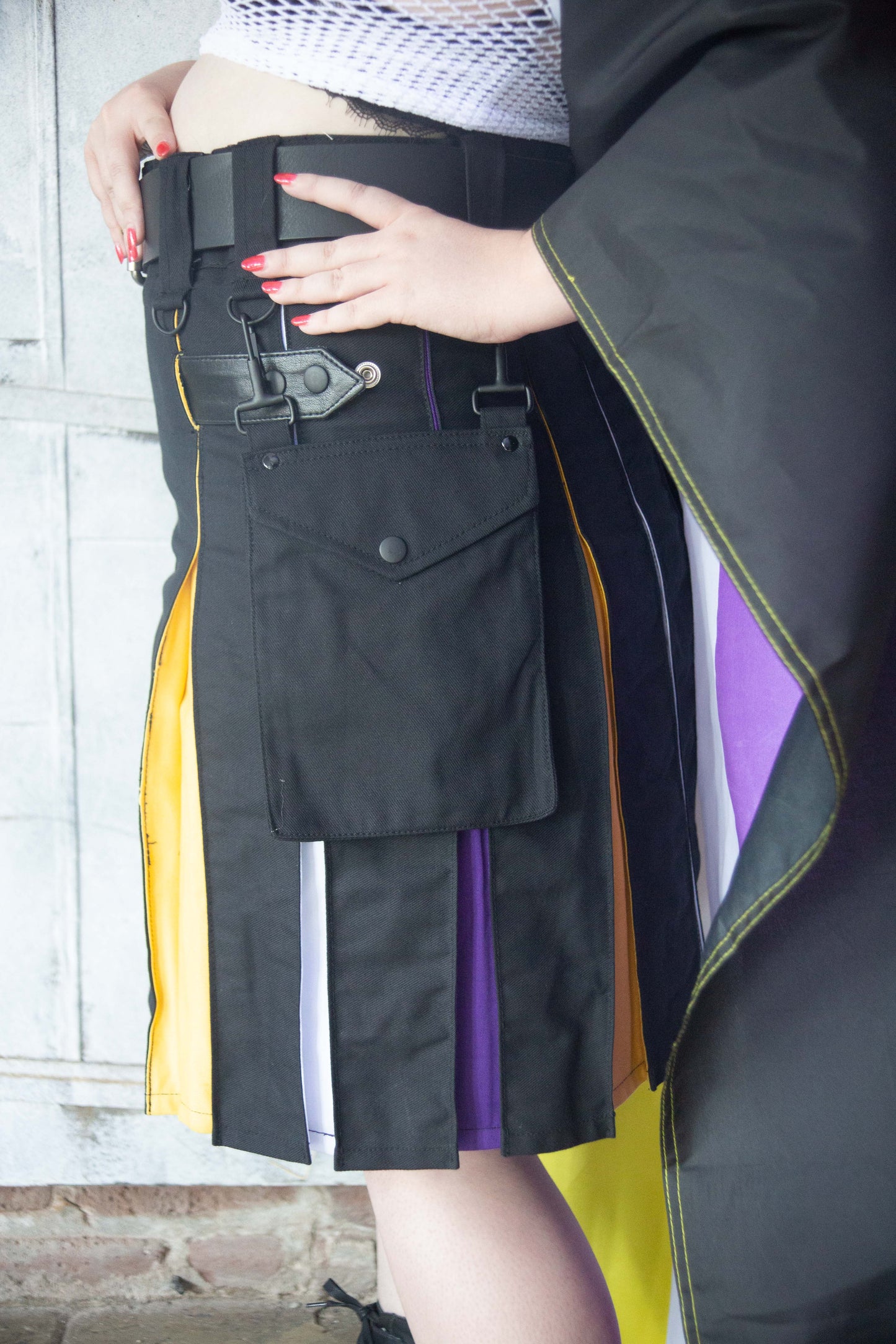 Model wearing Nonbinary Pride Flag Heritage Kilt, with hands on kilt belt