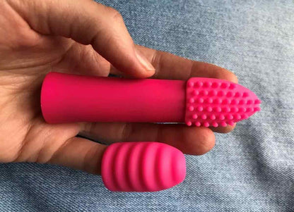 A hand holding the pink Sensuelle Point Plus Vibrator and attachments.