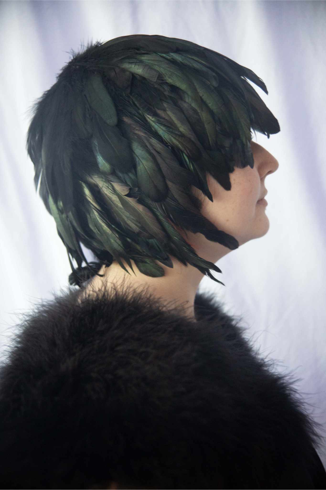 Model facing right wearing Schlappen Feather Wig