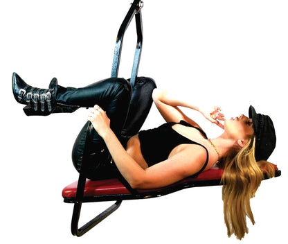 A model wearing a leather outfit laying in the red Sling Swing Model A.