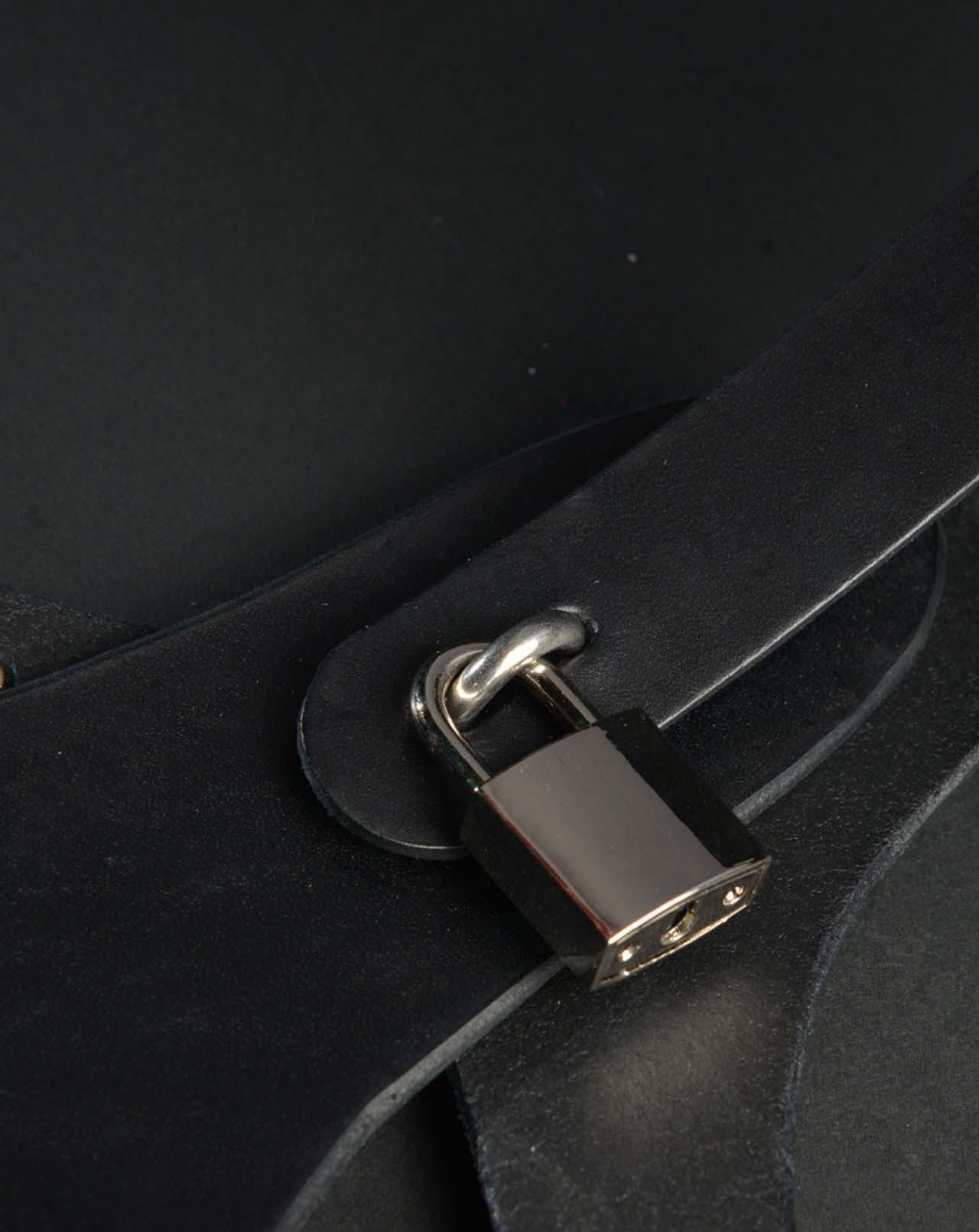 A close up of one of the locking mechanisms with lock on the Adjustable Leather Vaginal Chastity Belt.
