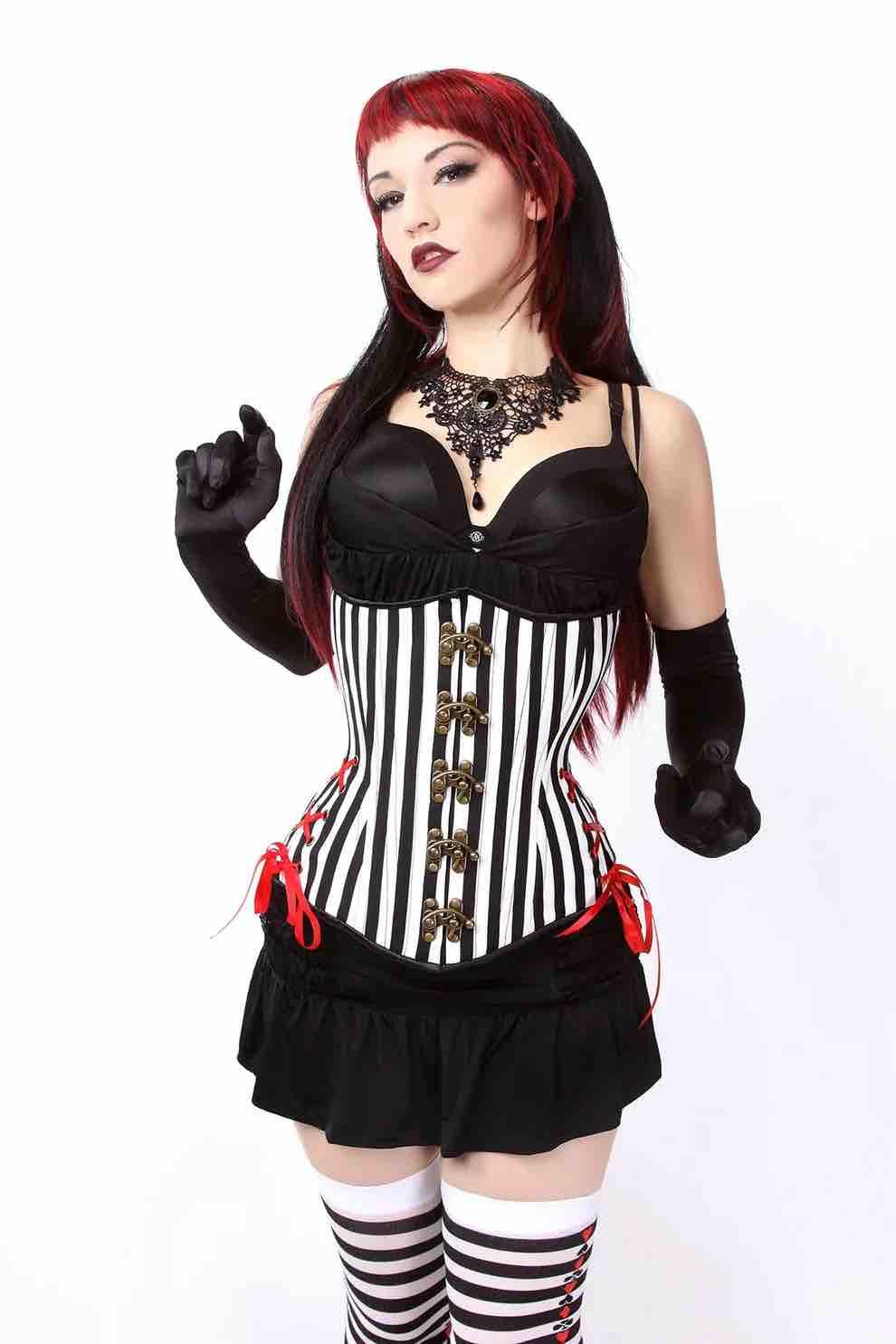 A model wearing the Circus Riot Longline Hourglass Cincher over a black bra and skirt.